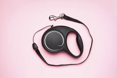 Black retractable dog leash on a pink background. Flat lay.の写真素材