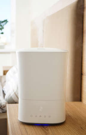 Modern humidifier in the bedroom on a curbstone, close-up. Vertycally.の写真素材