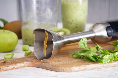 Hand blender for mixing organic raw fresh fruits for making vitamin diet smoothie, healthy food. Close up.の写真素材