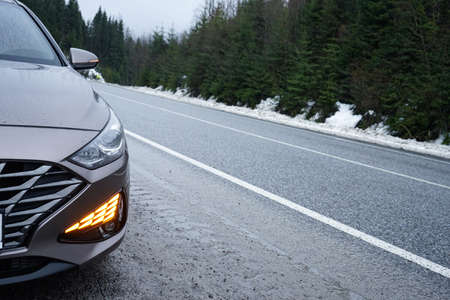 road trip concept. Car on a winter road in the forest, space for text.の写真素材