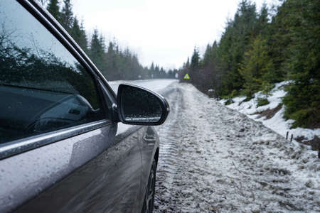 road trip concept. Car on a winter road in the forest.の写真素材