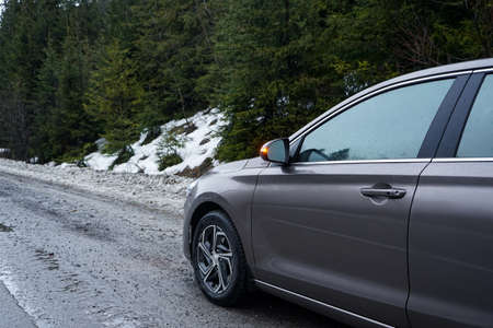 road trip concept. Car on a winter road in the forest.の写真素材