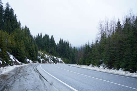 Road trip concept, winter trip. Empty country road in winter, roadside in the snow.の写真素材