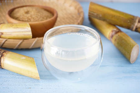 Fresh cane juice and sugar cane on a wooden background.の写真素材