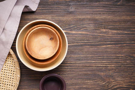 Dishes for serving and eating meals on a wooden background, top view. Modern wooden crockery, trendy...