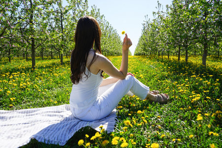 Young woman in a blooming spring garden. Blossoming apple orchard in spring.の写真素材