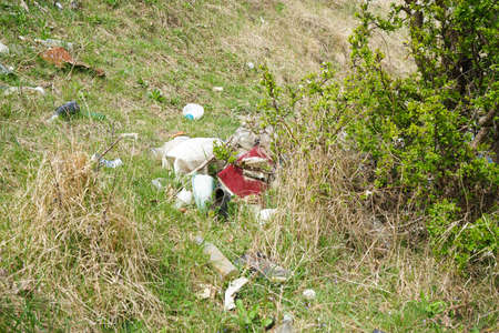 A pile of rubbish in a clearing in the countryside on a spring day. Concept of ecology. out of focus.の写真素材