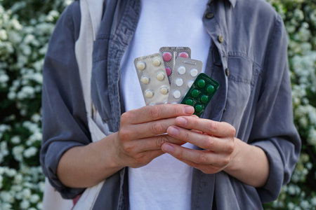 Female hands hold pills from outdoors, health and medical concept.の写真素材