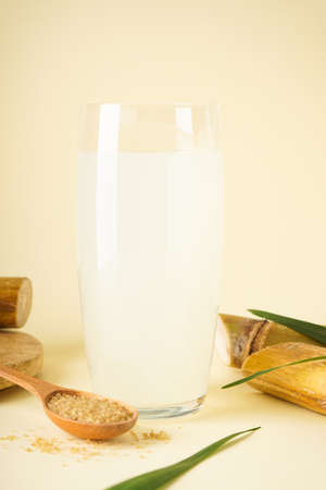 Fresh cane juice and brown sugar on a yellow background. vertically.