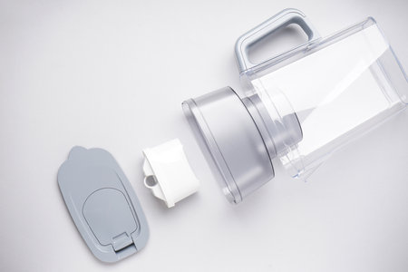 A disassembled jug for filtering water on a gray background. top view.