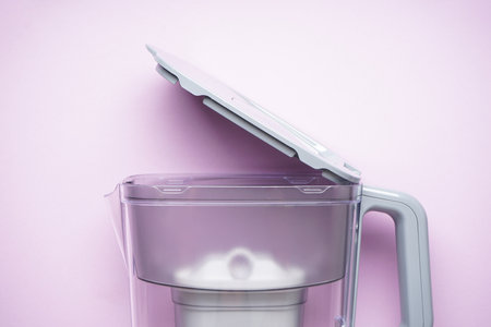 Pitcher for filtering water on a purple background, top view. close-up.の写真素材