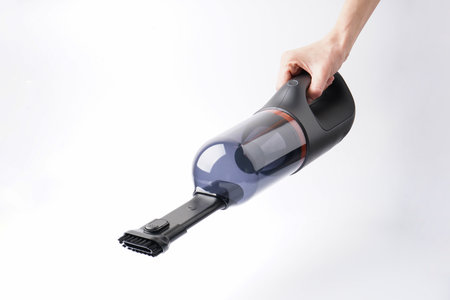 Hand holding car vacuum cleaner isolated on white background.の写真素材