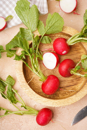 Ripe red radish in a wooden bowl on a beige background, fresh red radish. top view.の写真素材
