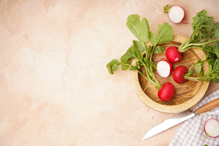 Ripe red radish in a wooden bowl on a beige background, space for text, fresh red radish. top view.の写真素材