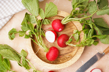 Ripe red radish in a wooden bowl on a beige background, fresh red radish. top view.の写真素材