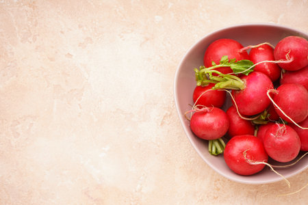 Fresh red radish in a bowl on a beige background, closeup, space for text. Fresh red radish.の写真素材