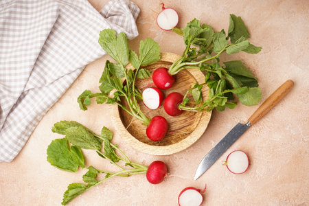 Ripe red radish in a wooden bowl on a beige background, fresh red radish. top view.の写真素材