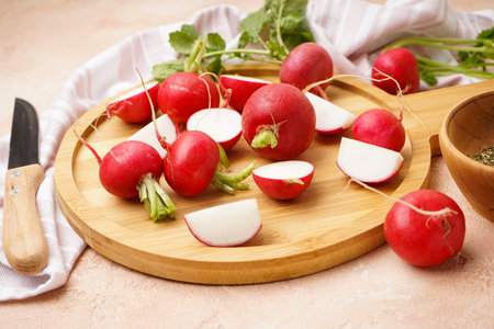 Fresh red radish on cutting board on a beige background. close-up.の写真素材