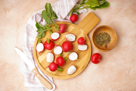 Fresh red radish on cutting board and spice on a beige background, top view. flat lay.の写真素材