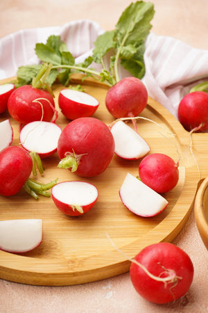 Fresh red radish on cutting board on a beige background. close-up.の写真素材