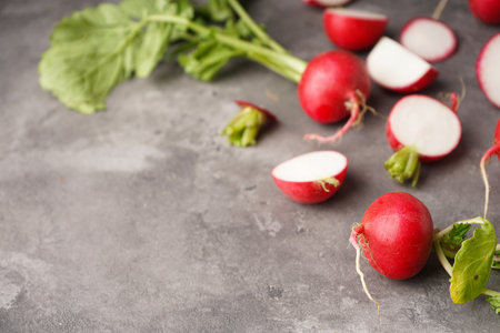 Fresh red radish slice with leaves on gray background, space for text, close-up.の写真素材