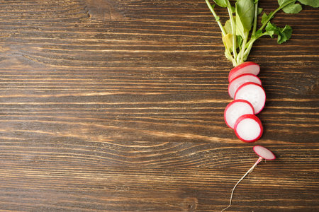 Fresh red radish slices on wooden background, space for text. flat lay.の写真素材