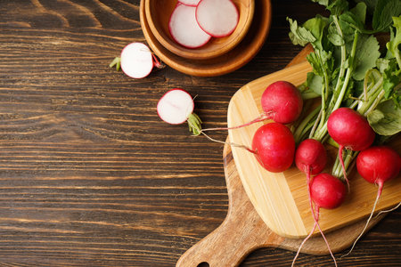 Fresh red radish and kitchen board on wooden background.の写真素材