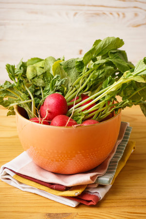 Fresh red radish in bowl on a wooden background, close-up.の写真素材
