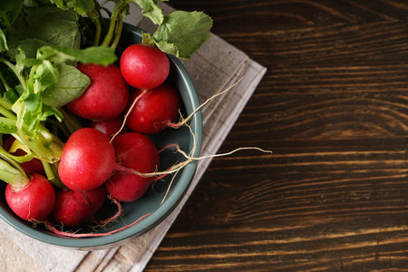 Fresh red radish in bowl on wooden background.の写真素材