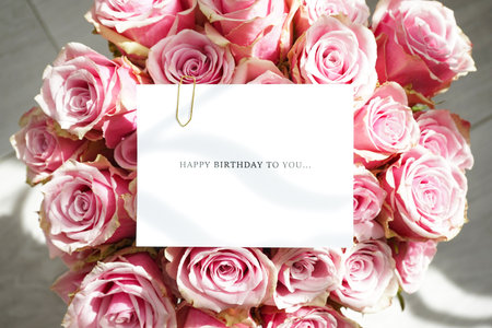 Bouquet of beautiful pink roses with a greeting card, top view. close-up.の写真素材
