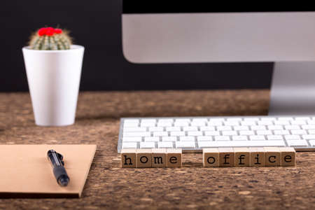 Close up view of a black work desk interior with a laptop computer, a cup of coffee, paper, pen and,...