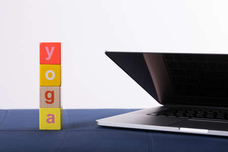 yoga mat with laptop computer ready for an online class or classes with lettering yoga. Â© Michele Agostinis / Visualbrand Photographyの写真素材