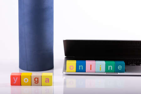 yoga mat with laptop computer ready for an online class or classes with lettering yoga online. Â© Michele Agostinis / Visualbrand Photographyの写真素材
