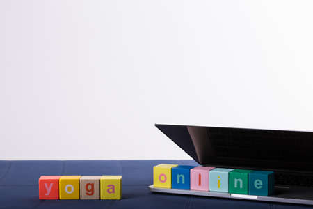 yoga mat with laptop computer ready for an online class or classes with lettering yoga online. Â© Michele Agostinis / Visualbrand Photographyの写真素材