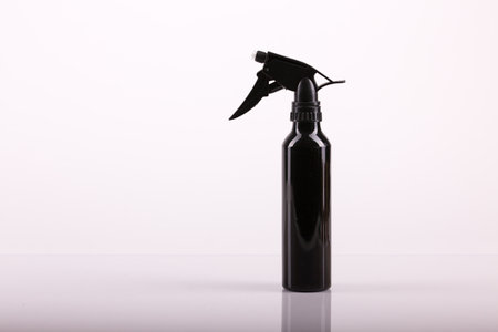 Black hair spray bottle with white background: equipment for free home haircutの写真素材