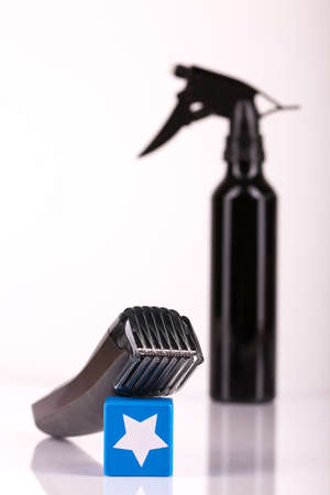 Black hair spray bottle and an electric shaver with white background: equipment for free home...