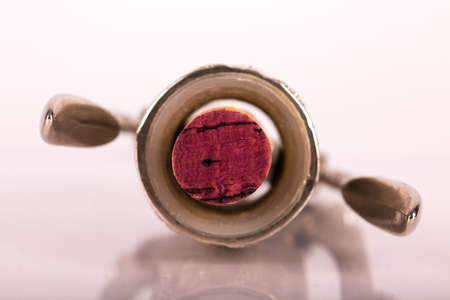 Red wine bottle, cork stopper and an italian prestigious corkscrew on a white background