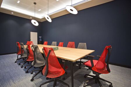 this is photo of interior design of meeting rooms with red chairs and wooden tables with best...