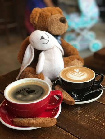 two coffee milk in a cup with two teddy bearsの写真素材