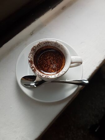 milk coffee with chocolate powder on it in the cupの写真素材