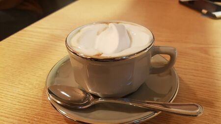 milk coffee with ice cream on top in a white cupの写真素材