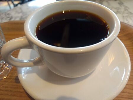Black coffee in a clear white cup with motion blurの写真素材