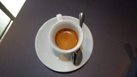 Milk coffee with half the contents in a white cupの写真素材
