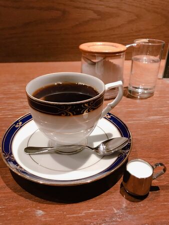 black coffee in a white cup on a wooden tableの写真素材