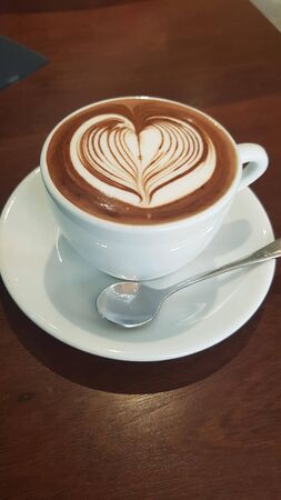 heart-shaped cappuccino in a white cupの写真素材