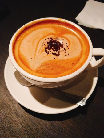 cappuccino coffee in a white cup on the tableの写真素材