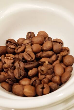 brown coffee bean in a white containerの写真素材