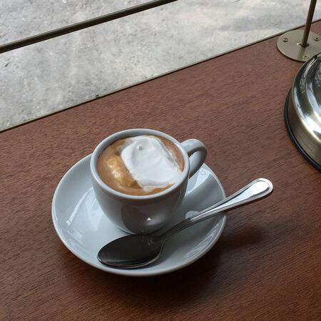 milk coffee with ice cream in a cup on a wooden tableの写真素材