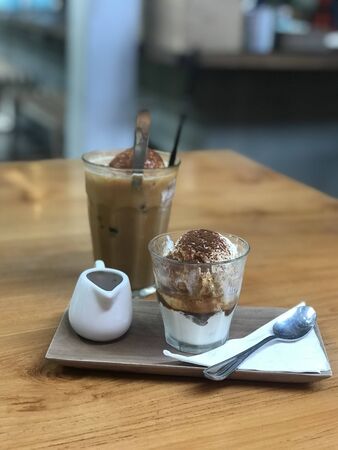 milk coffee and ice cream in a glass on a wooden tableの写真素材