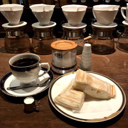 black coffee with toast on a plate on the tableの写真素材